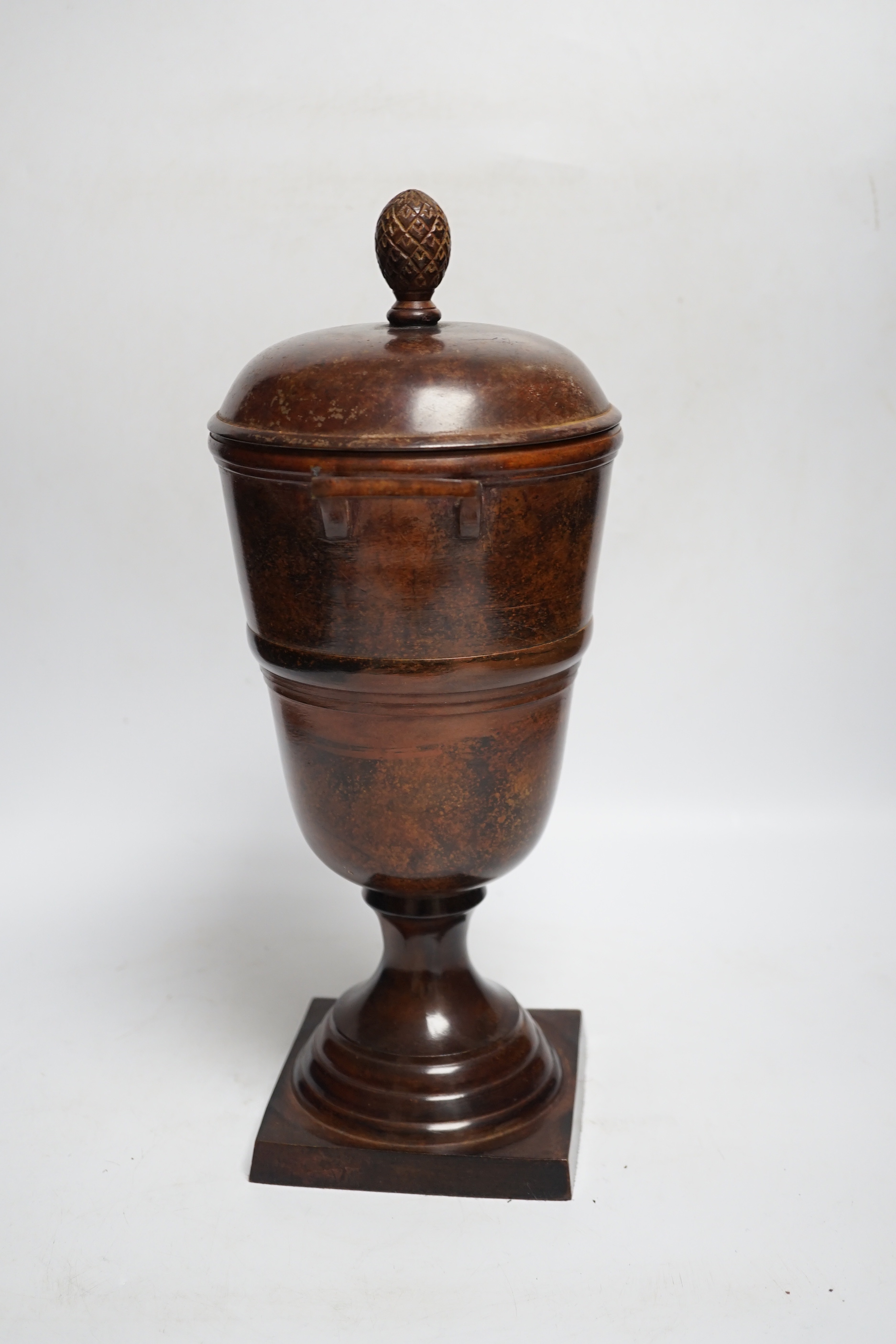 A patinated cast metal two-handled urn and cover with acorn finial, 36.5cm high